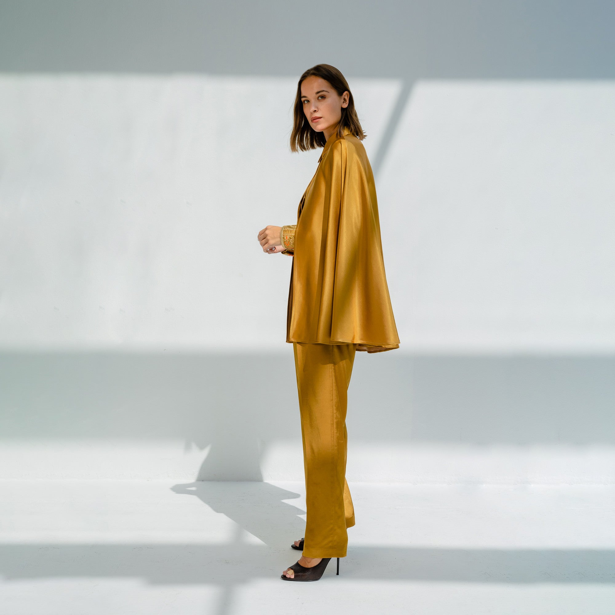 Cobrancosa Golden Silky Satin Double Face Jumpsuit with Colorful Waist Detail and Attached Cape by Lara Ali